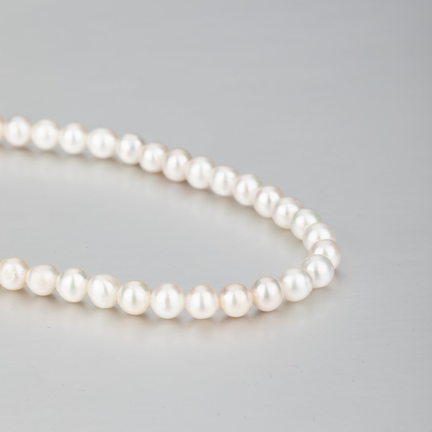 STELLA MARGARITA handcrafted pearl necklace for women with lustrous white pearls on gray background