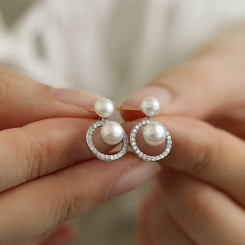 STELLA MARGARITA double freshwater pearl earrings with silver rhinestone hoop design held by hand