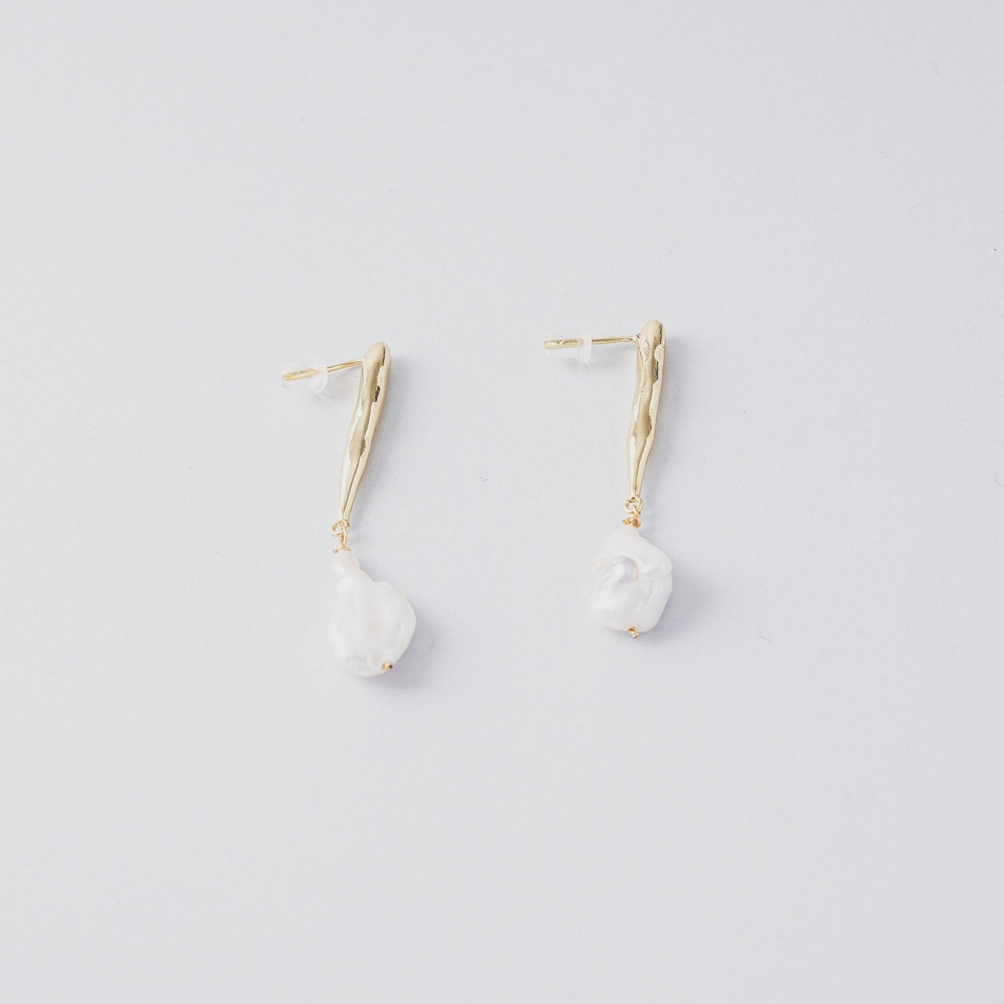 STELLA MARGARITA baroque pearl drop earrings with gold textured hooks on white background