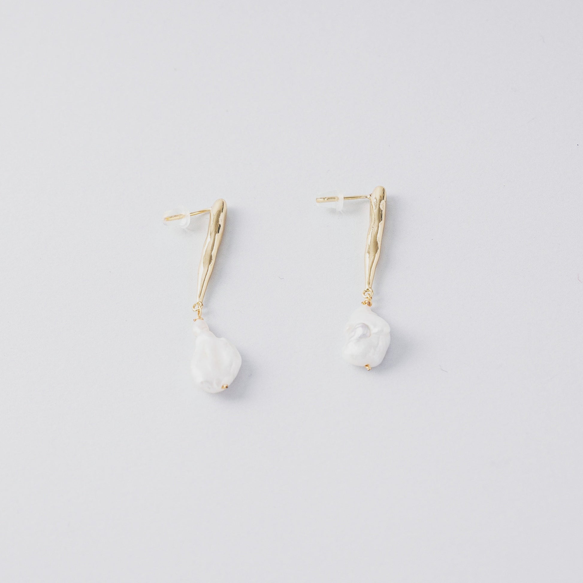 STELLA MARGARITA baroque pearl drop earrings with gold textured hooks on white background