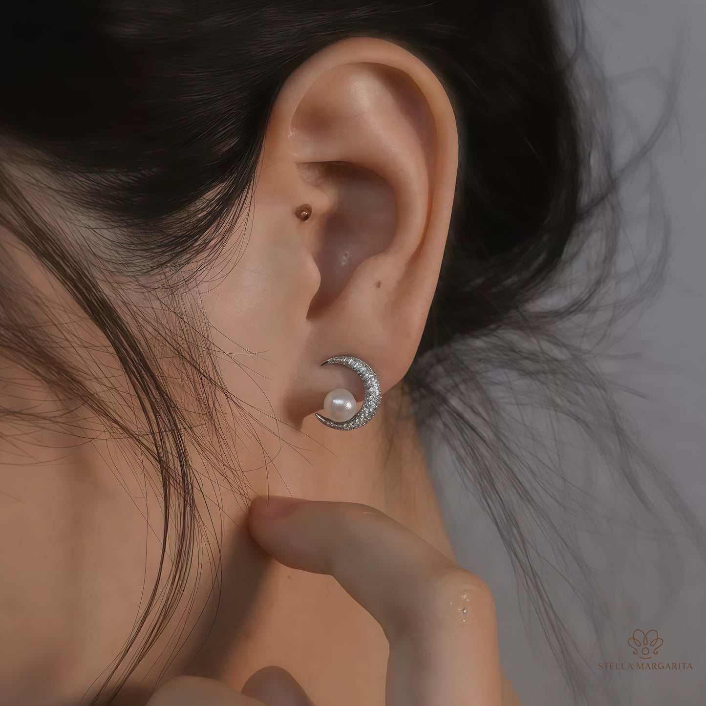 STELLA MARGARITA celestial moon pearl earrings worn on ear with crescent moon design and pearl detail