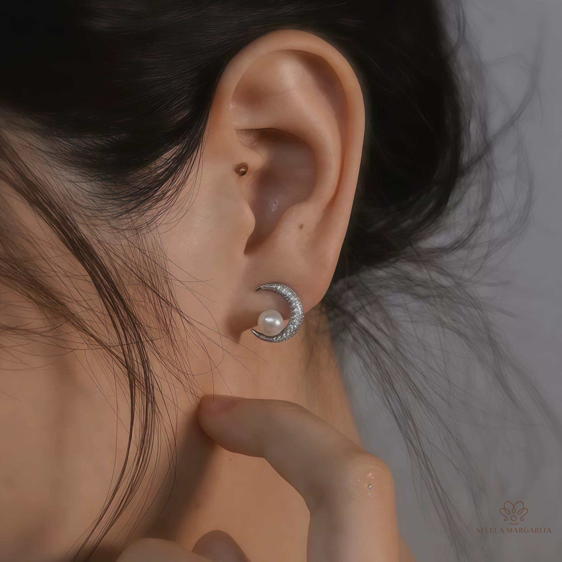 STELLA MARGARITA celestial moon pearl earrings worn on ear with crescent moon design and pearl detail
