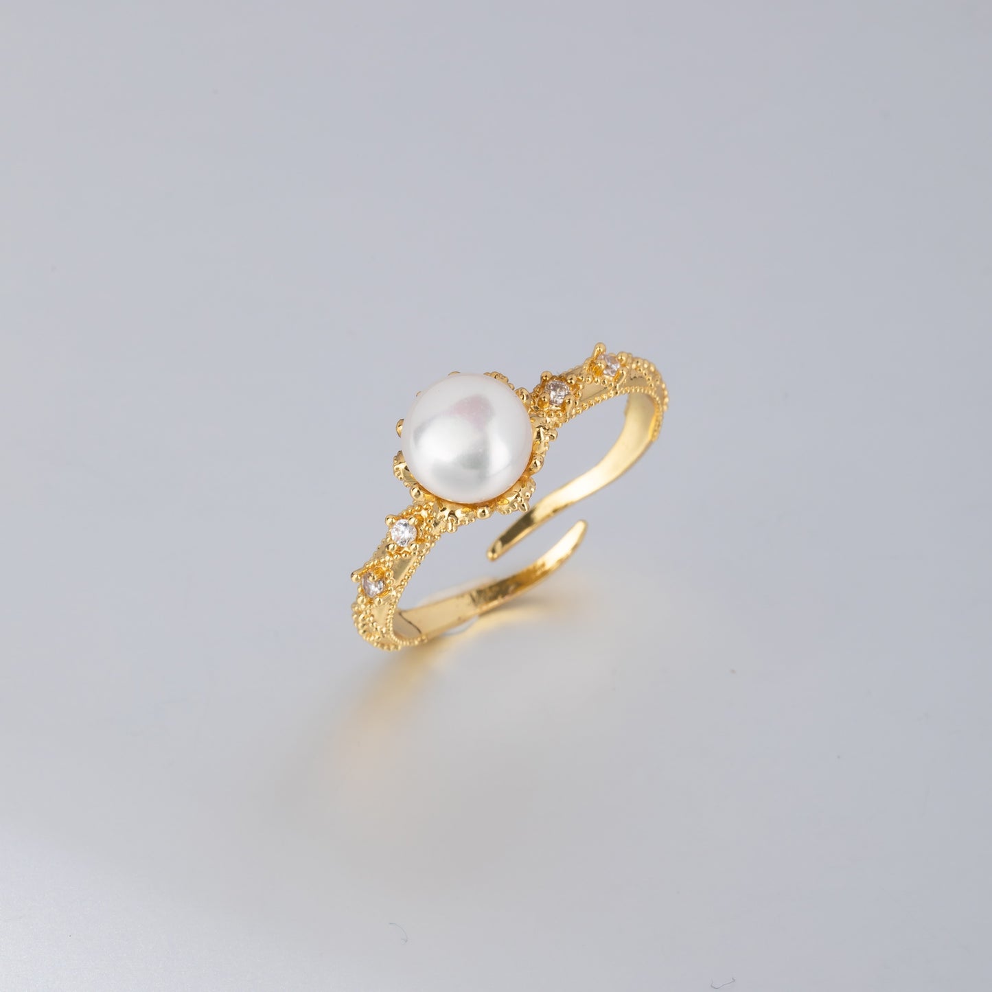 Handcrafted gold pearl engagement ring featuring a central white pearl and intricate gold detailing