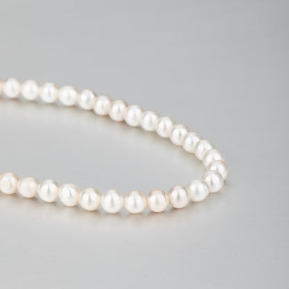 STELLA MARGARITA handcrafted pearl necklace for women with lustrous white pearls on gray background