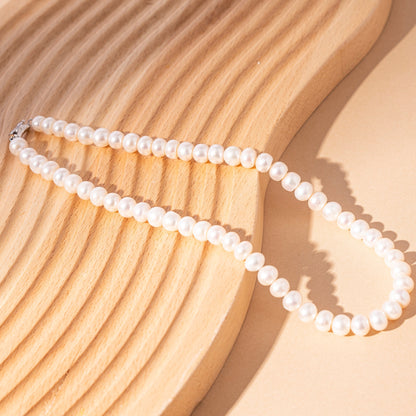 STELLA MARGARITA handcrafted pearl necklace for women displayed on a textured wooden surface