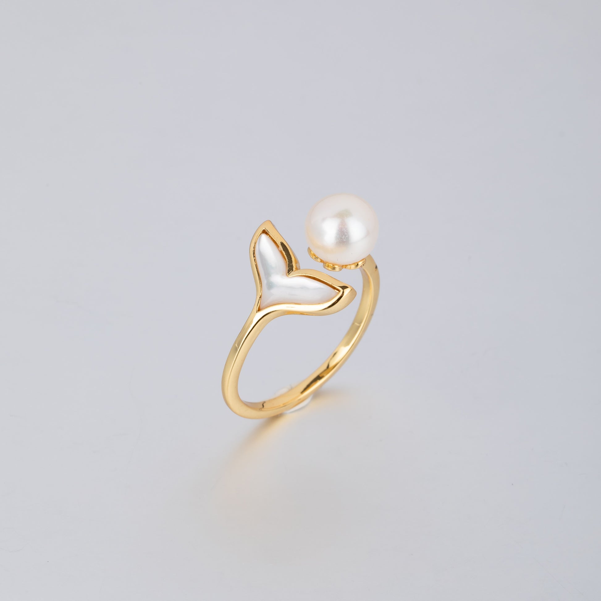 18K gold pearl mermaid ring featuring a gold band with a mermaid tail and a white pearl