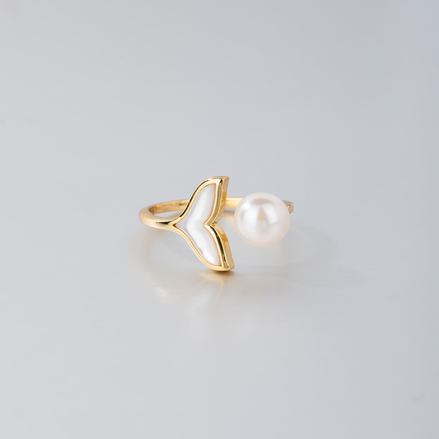 STELLA MARGARITA 18K gold pearl mermaid ring with a delicate gold tail and white pearl on a white background