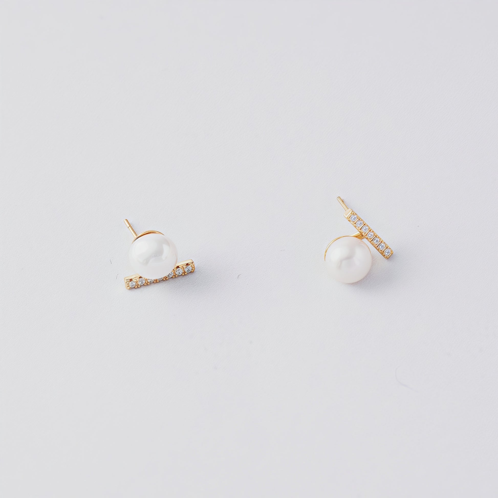 STELLA MARGARITA balance beam pearl stud earrings with gold and small crystals on white background