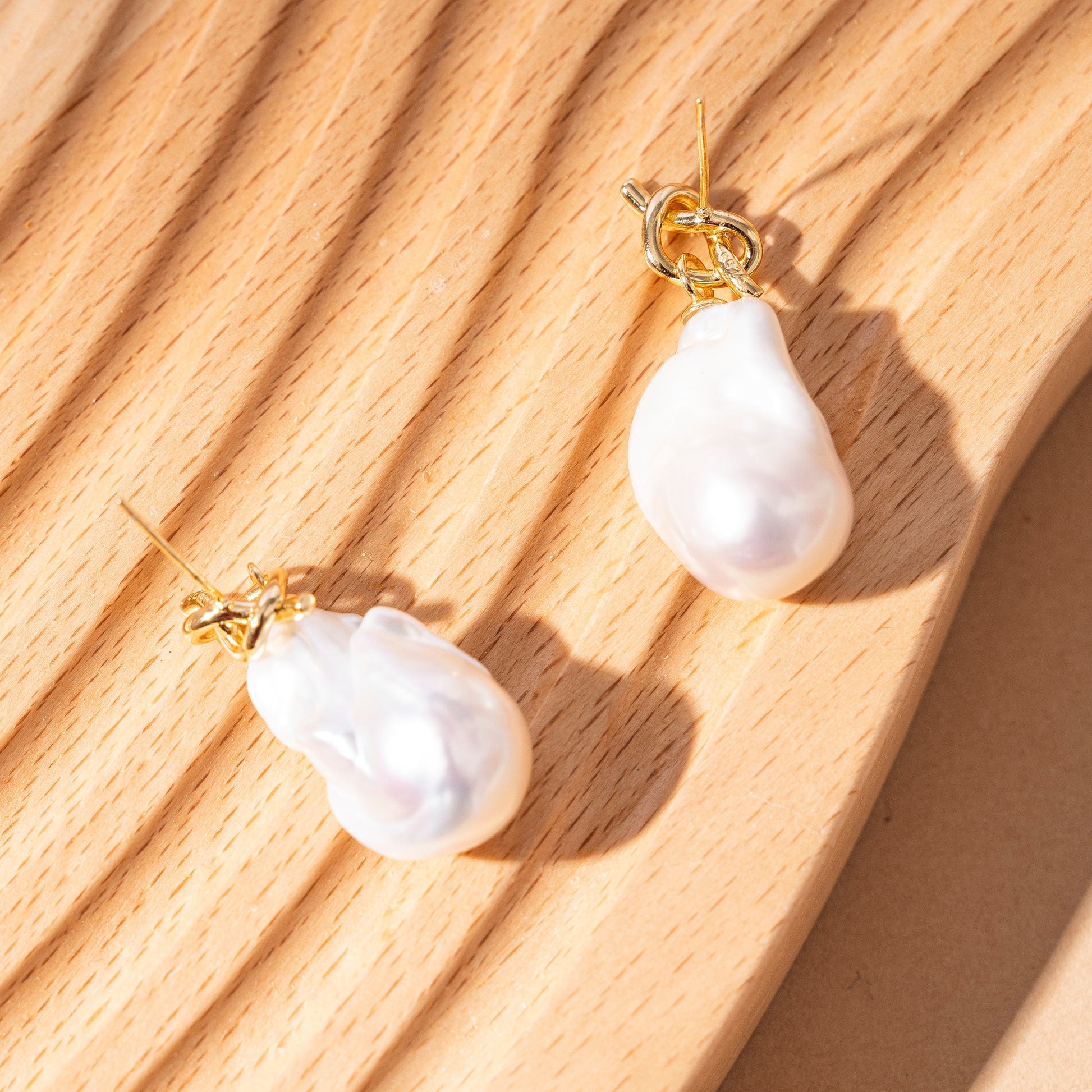 STELLA MARGARITA elegant baroque freshwater pearl earrings with gold hooks on wooden surface