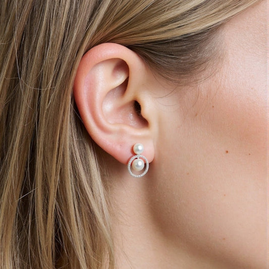 STELLA MARGARITA double freshwater pearl earrings worn on a woman's ear with a silver hoop design