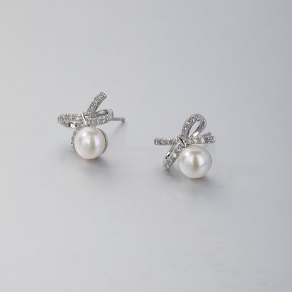 Elegant silver ribbon pearl stud earrings with sparkling crystal accents by STELLA MARGARITA