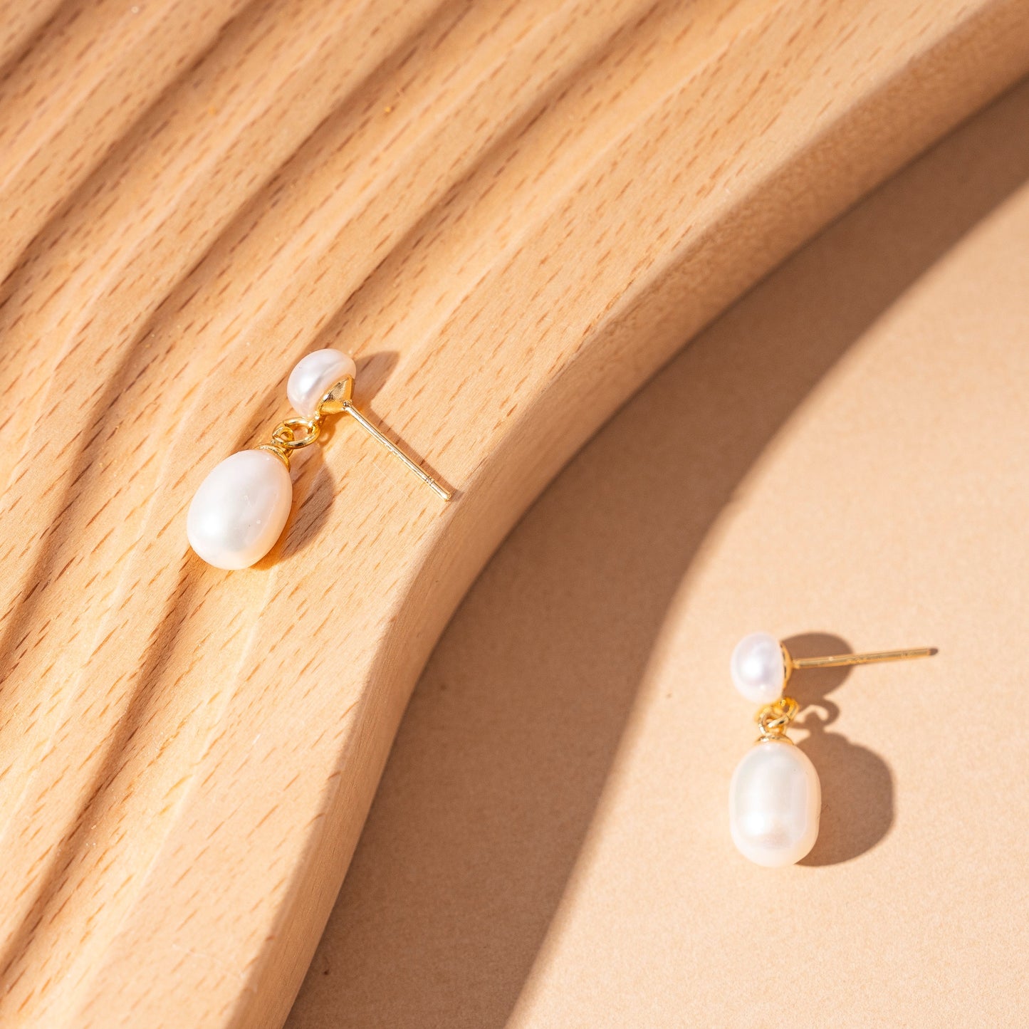 STELLA MARGARITA unique pearl earrings for women with gold accents on wooden surface