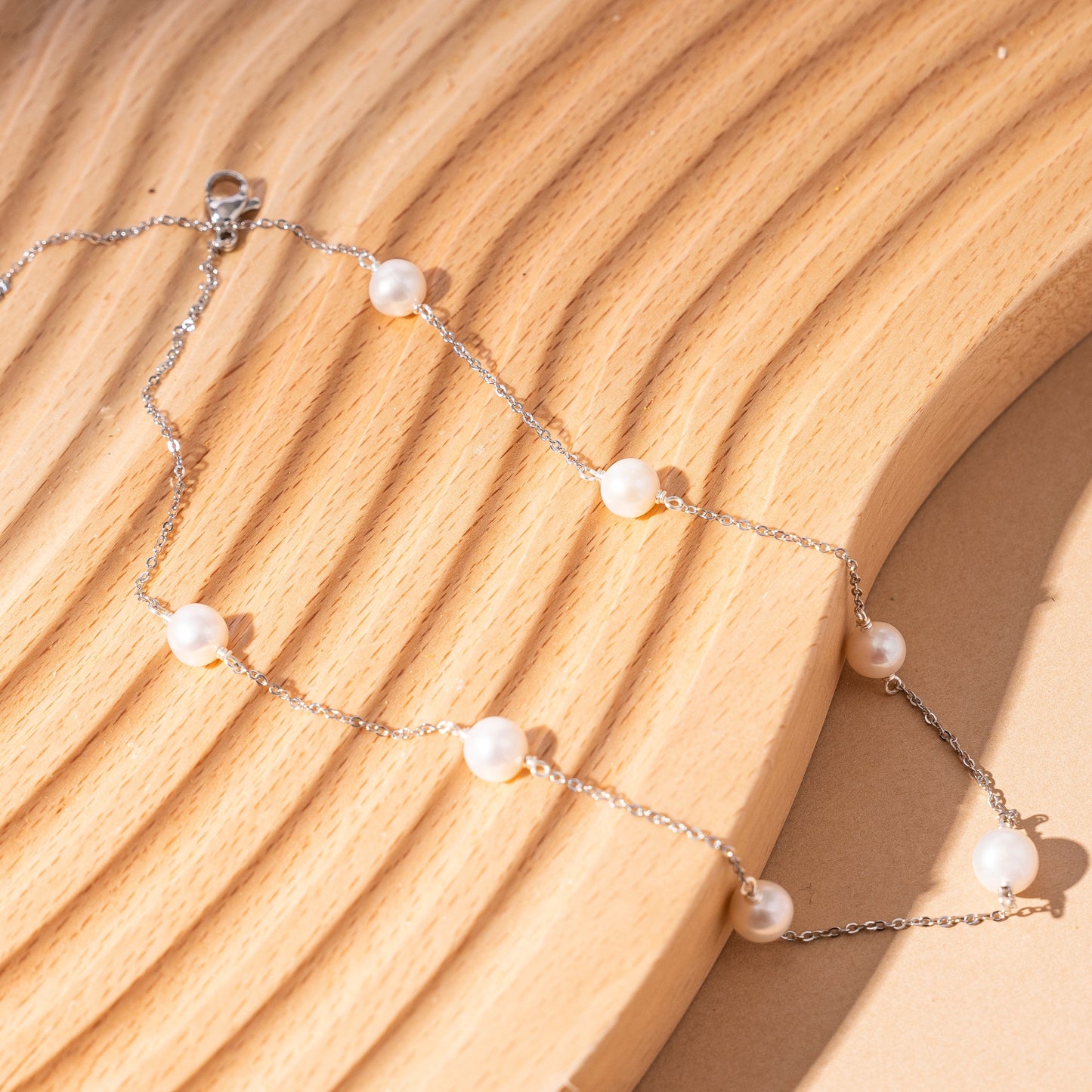 STELLA MARGARITA sterling silver freshwater pearl necklace with delicate chain on wooden surface