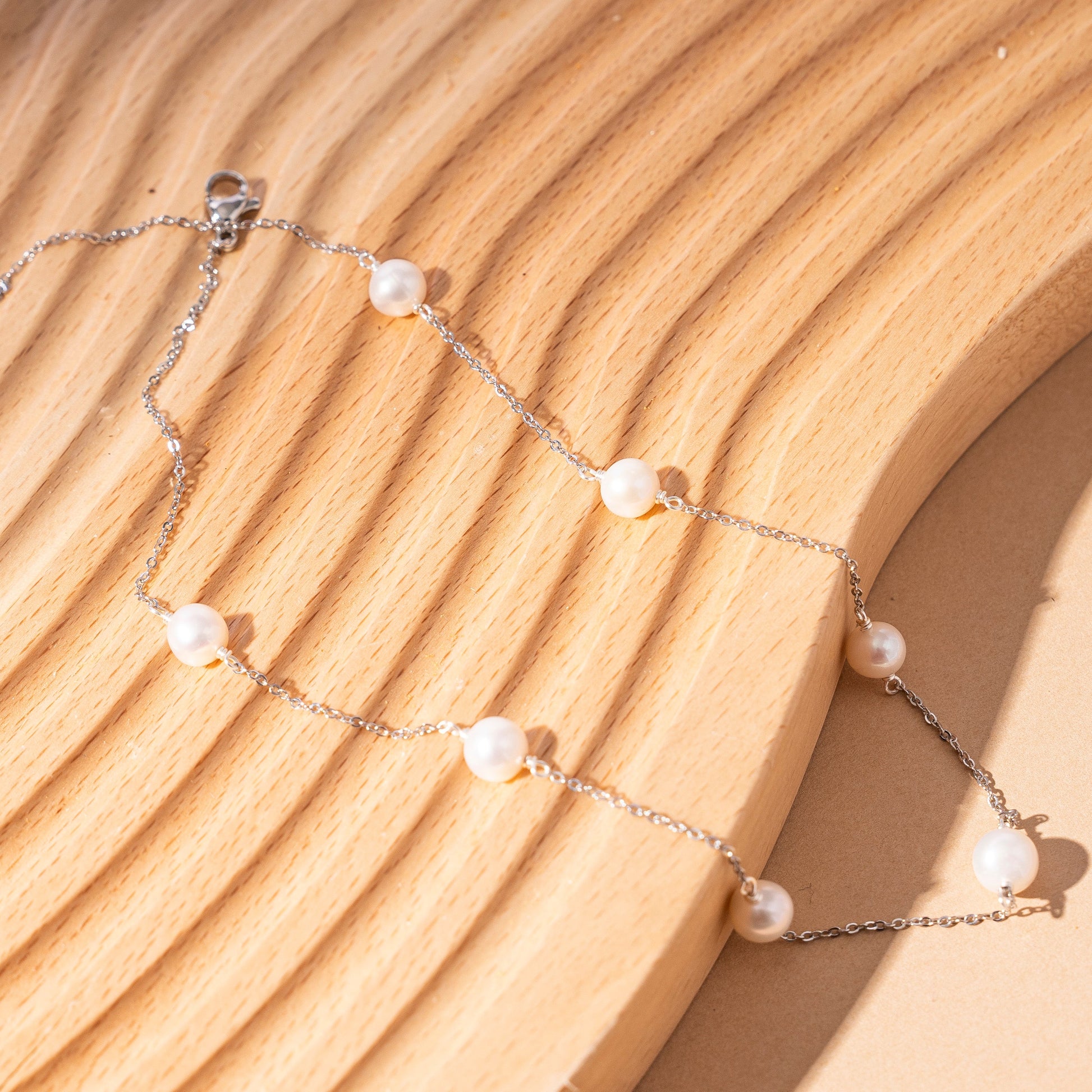 STELLA MARGARITA sterling silver freshwater pearl necklace with delicate chain on wooden surface